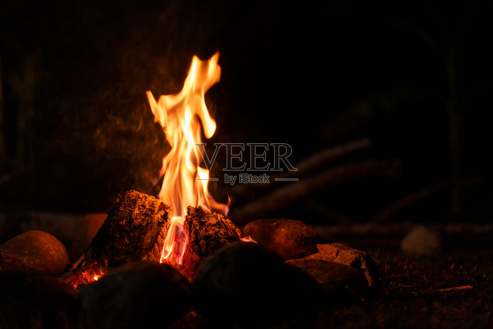 黑暗中燃烧的木柴。照片摄影图片