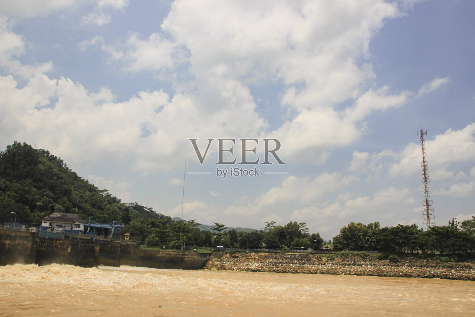 风景如画的河畔景观，建筑和塔楼在明亮的天空下照片摄影图片