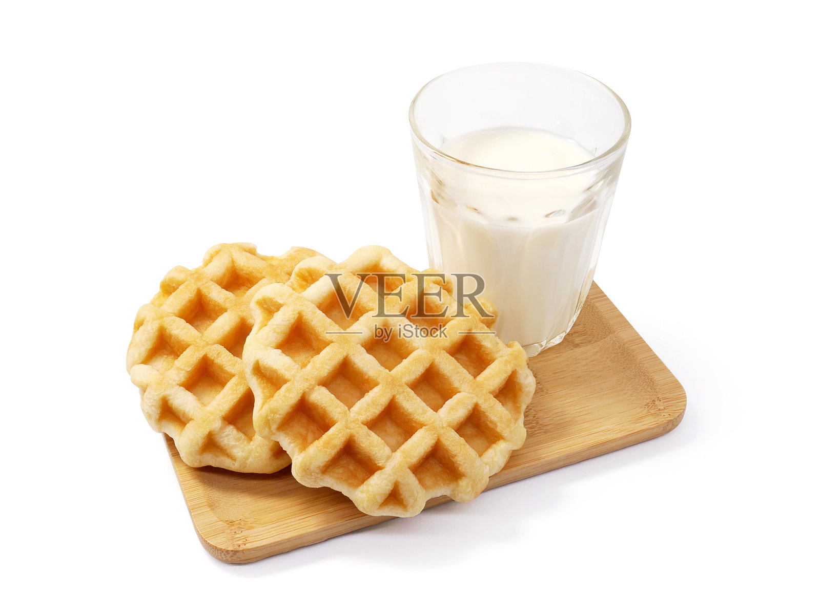 木托盘上的圆形华夫饼和一杯牛奶，背景为白色照片摄影图片