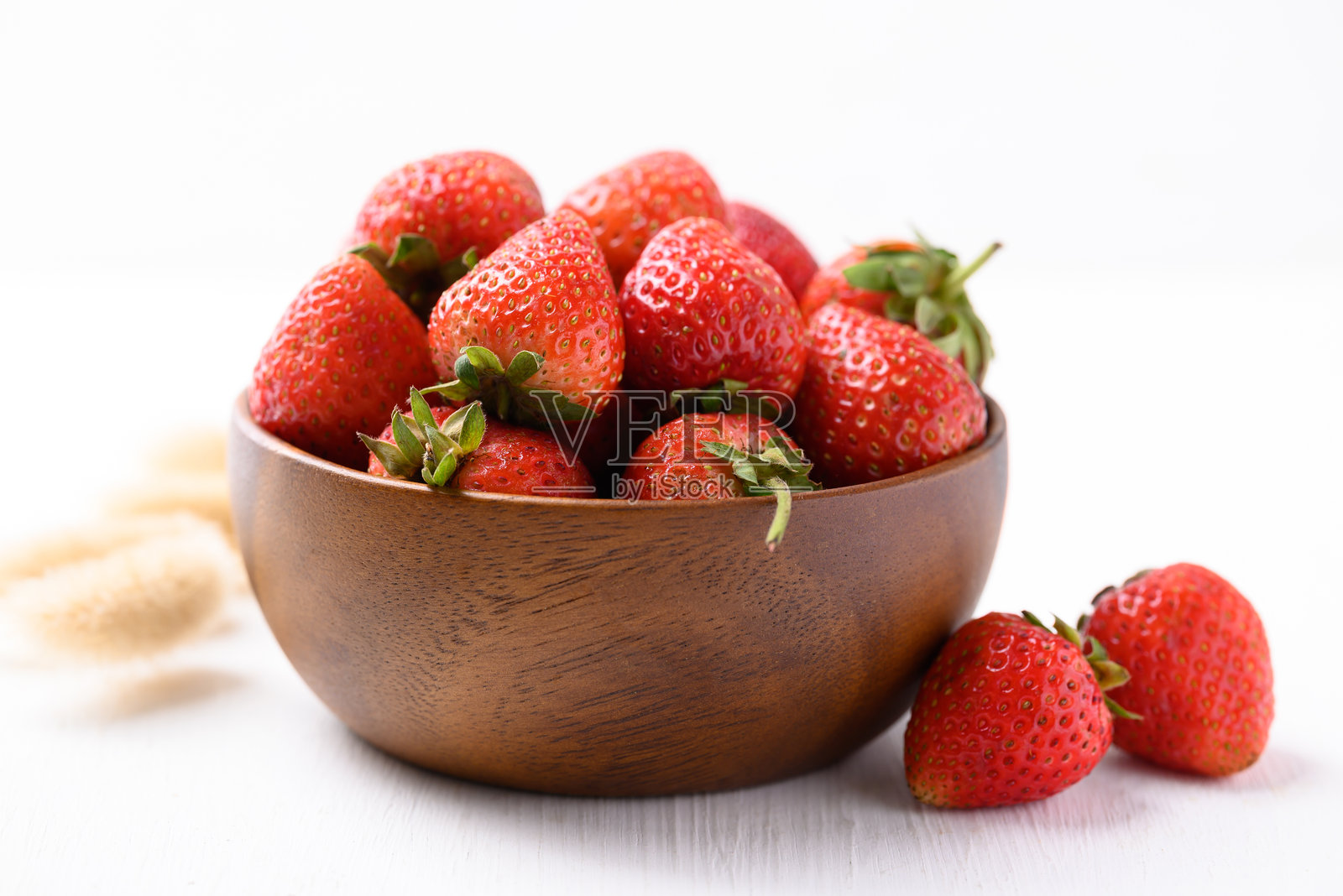 白色背景上的木碗里的草莓水果照片摄影图片