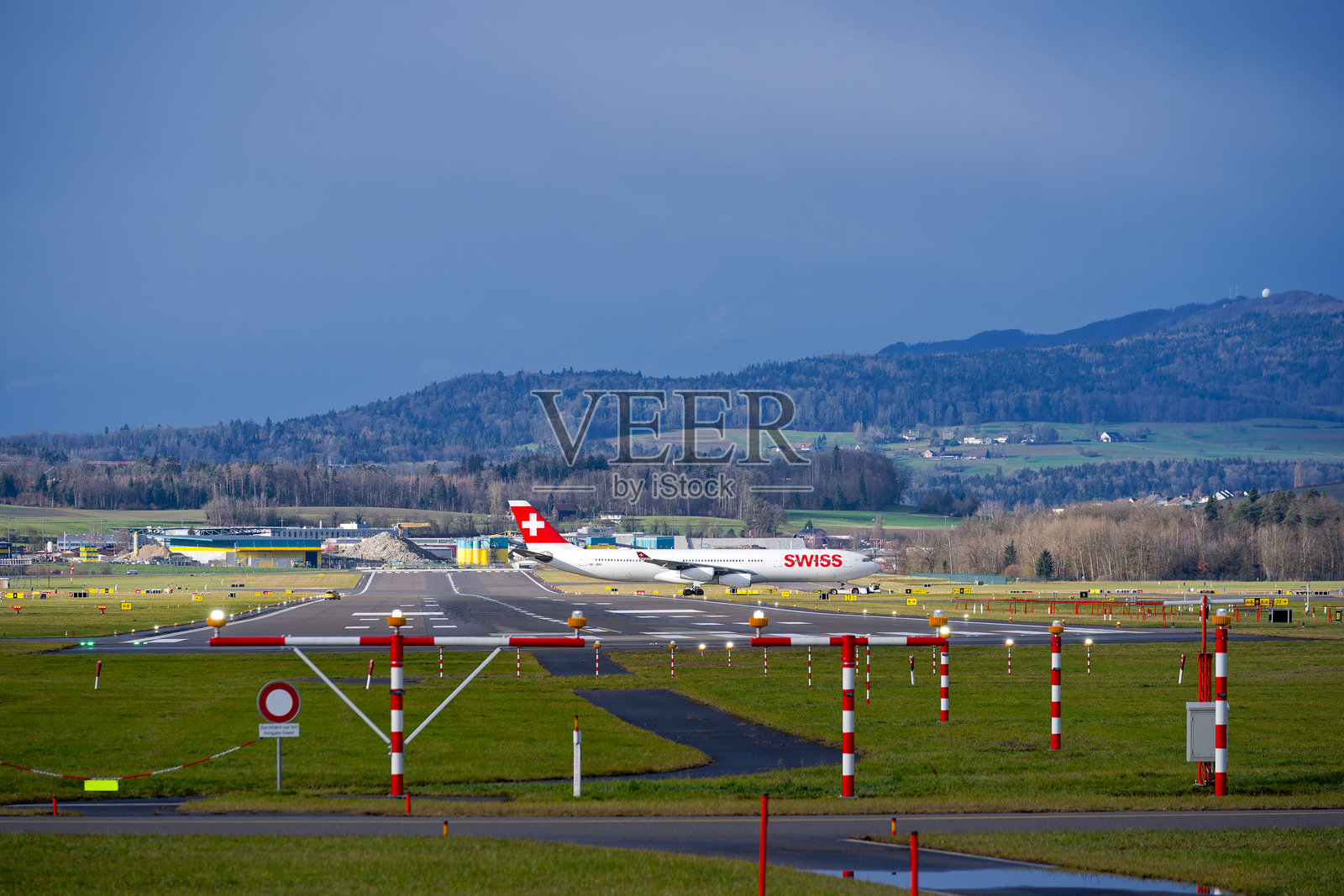 苏黎世克洛滕机场的美丽景色，瑞士航空的空客A340-313注册号HB-JMH在冬日的跑道上穿行。照片摄影图片