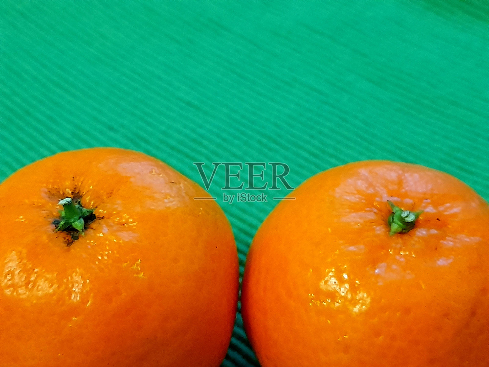 两个橘子与绿色背景。照片摄影图片