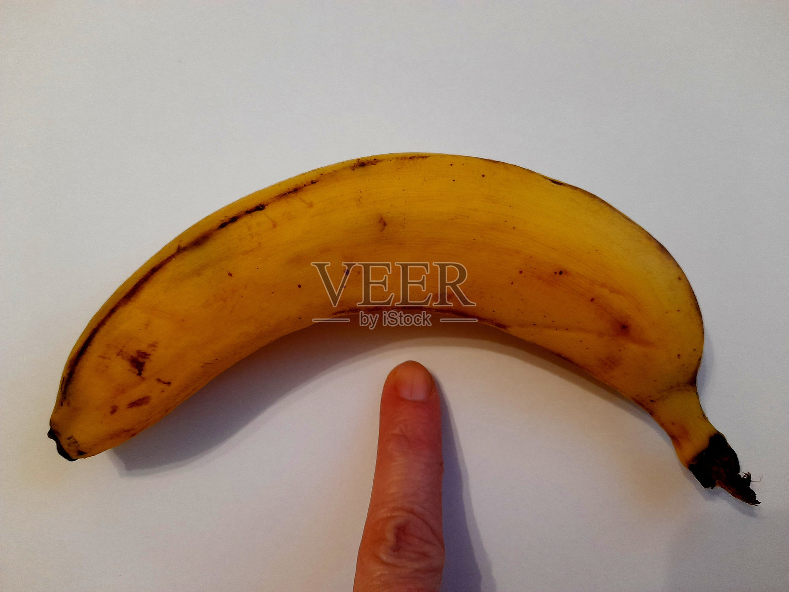 一整根香蕉与手和白色背景照片摄影图片