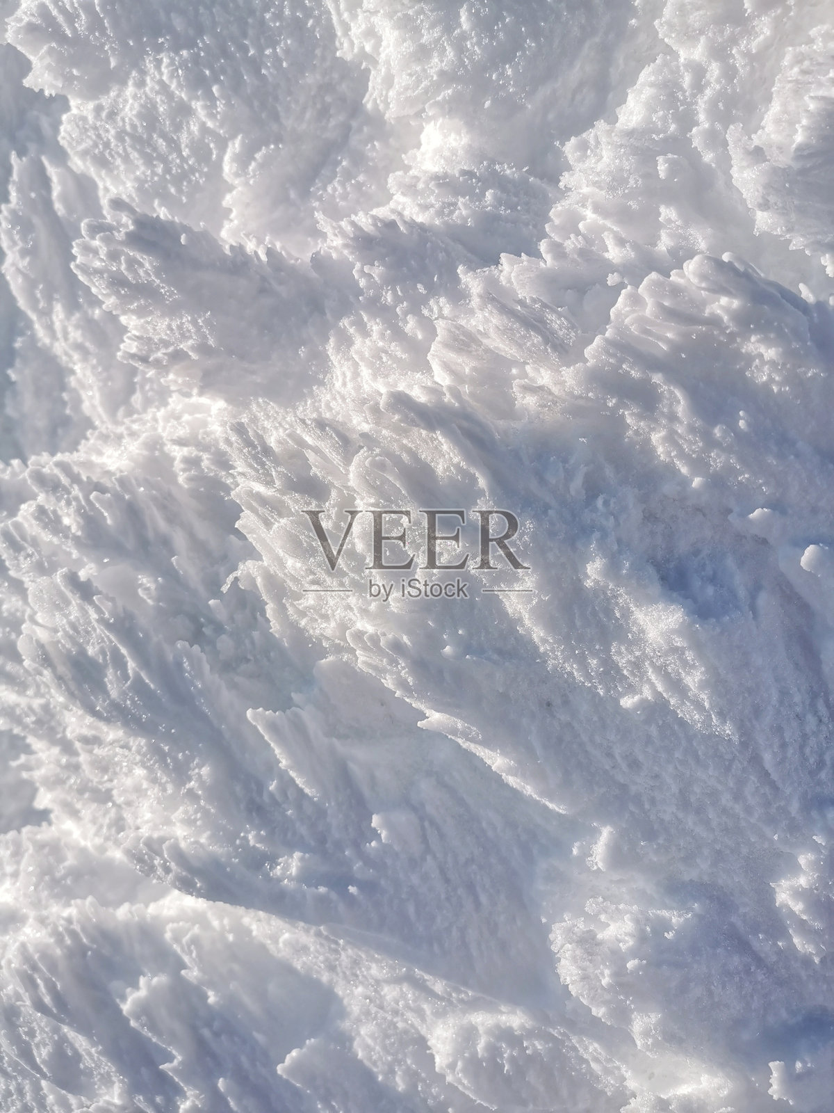 垂直冬季背景，雪覆盖的山面展示出复杂的图案和纹理照片摄影图片
