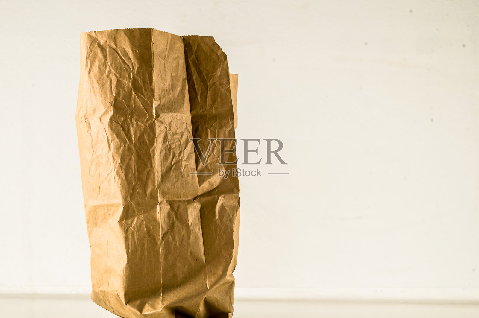 一个棕色纸袋放在白色表面上照片摄影图片