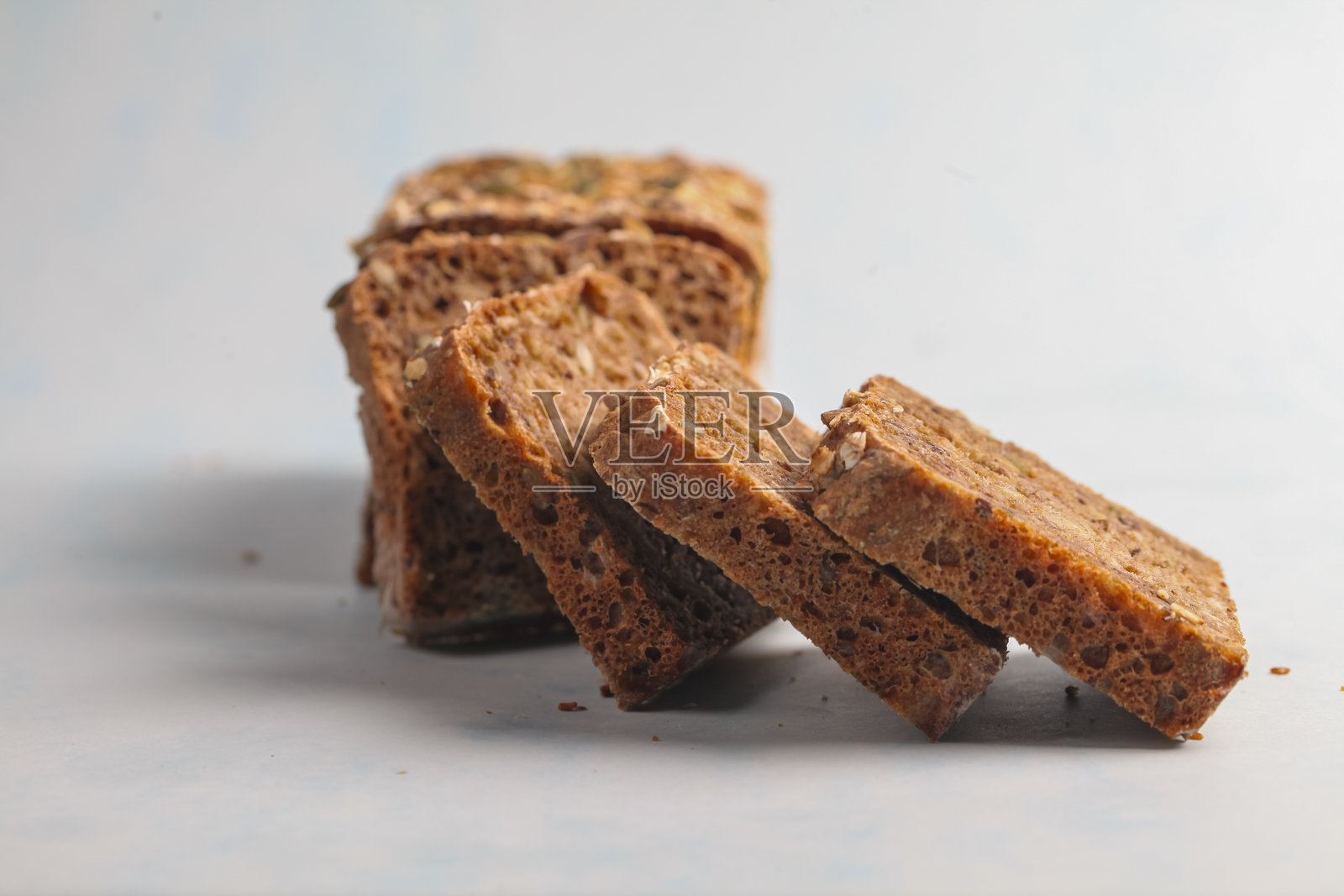 新鲜切片的全麦面包放在浅蓝色背景上照片摄影图片