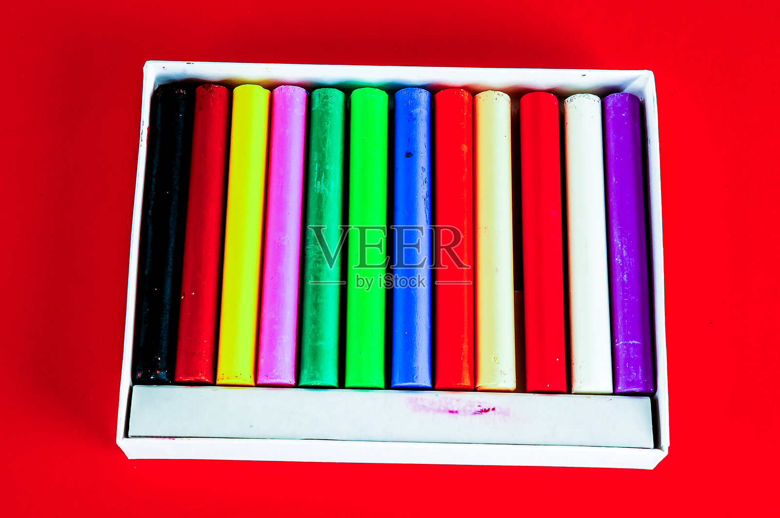 一盒蜡笔，背景为红色照片摄影图片