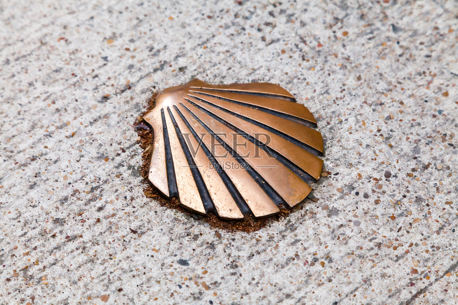 一个镶嵌在历史朝圣地的纹理石铺路上的青铜贝壳照片摄影图片