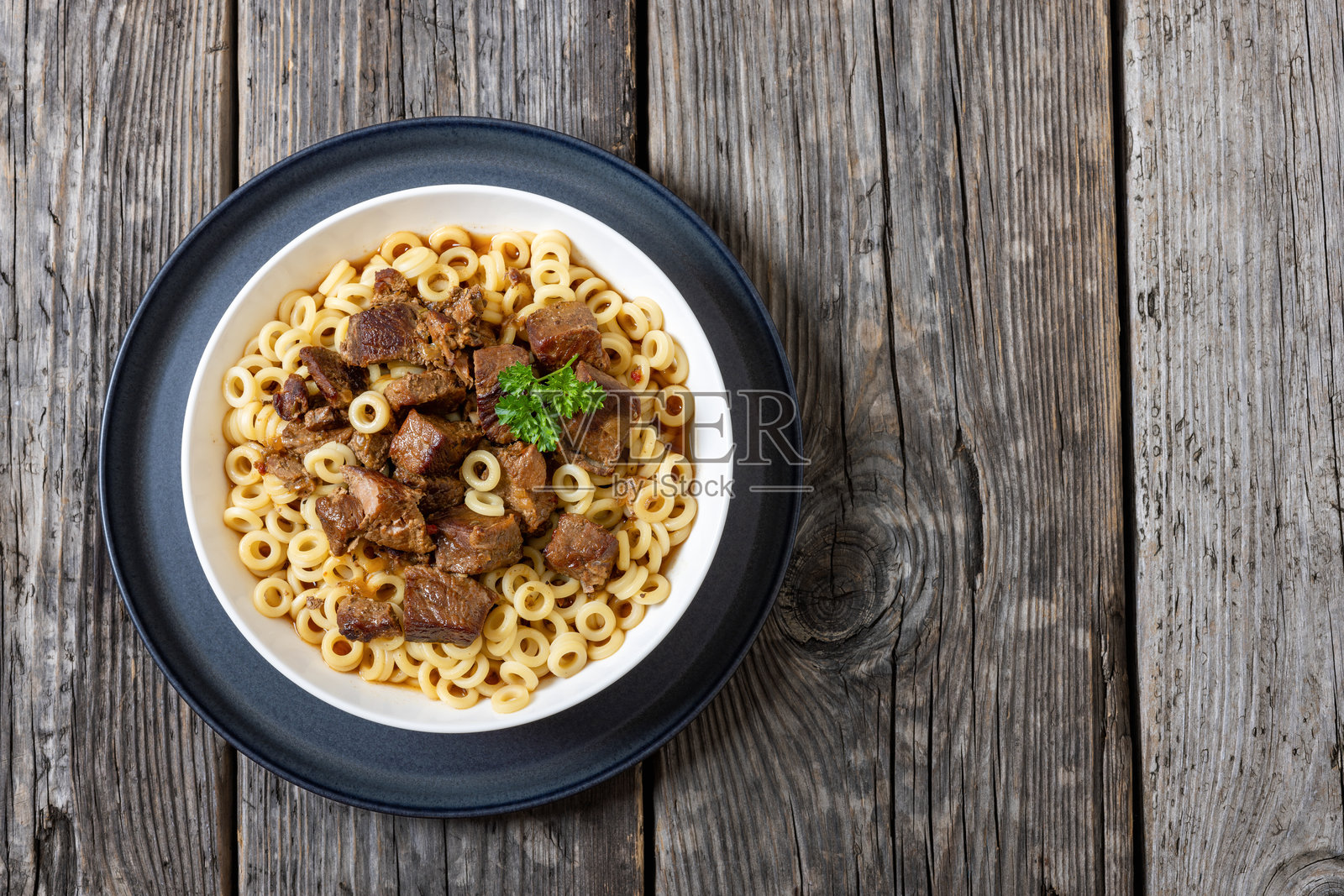 碗中盛着浇有炖肉的意大利面圈照片摄影图片