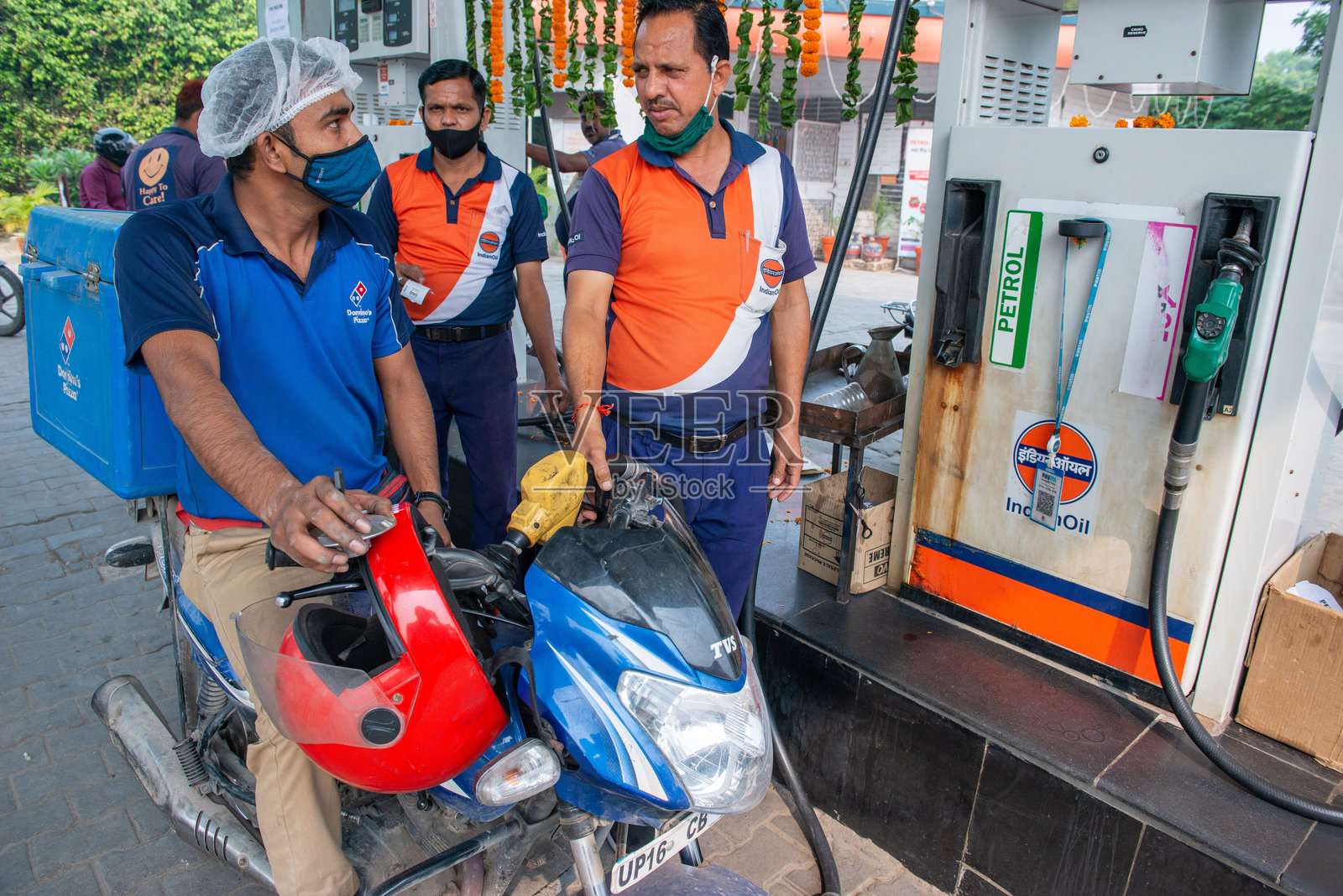 在加油站的达美乐送餐员照片摄影图片