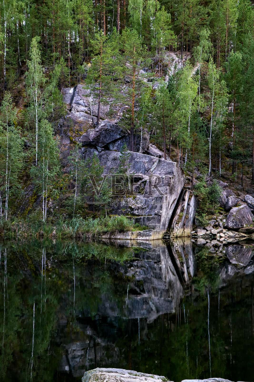 照片展示了一片滑石湖，湖中有岩石和树木。照片摄影图片
