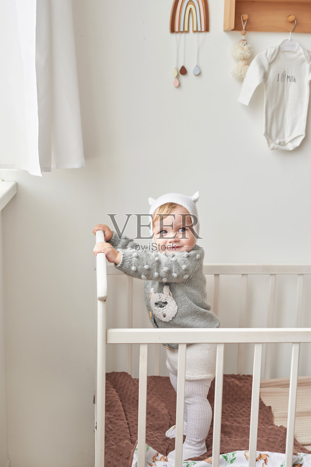 穿着针织毛衣的婴儿与木制玩具。母亲节。儿童保护日。快乐的孩子，幸福的童年。照片摄影图片