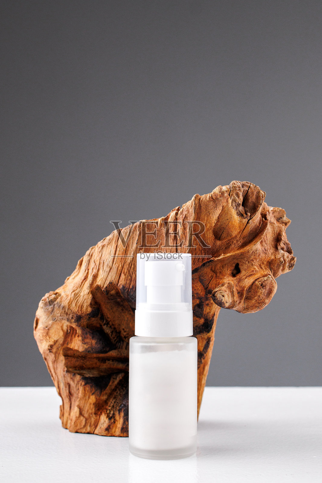 简单的美容产品展示在精致的木制底座上，背景为素色。照片摄影图片