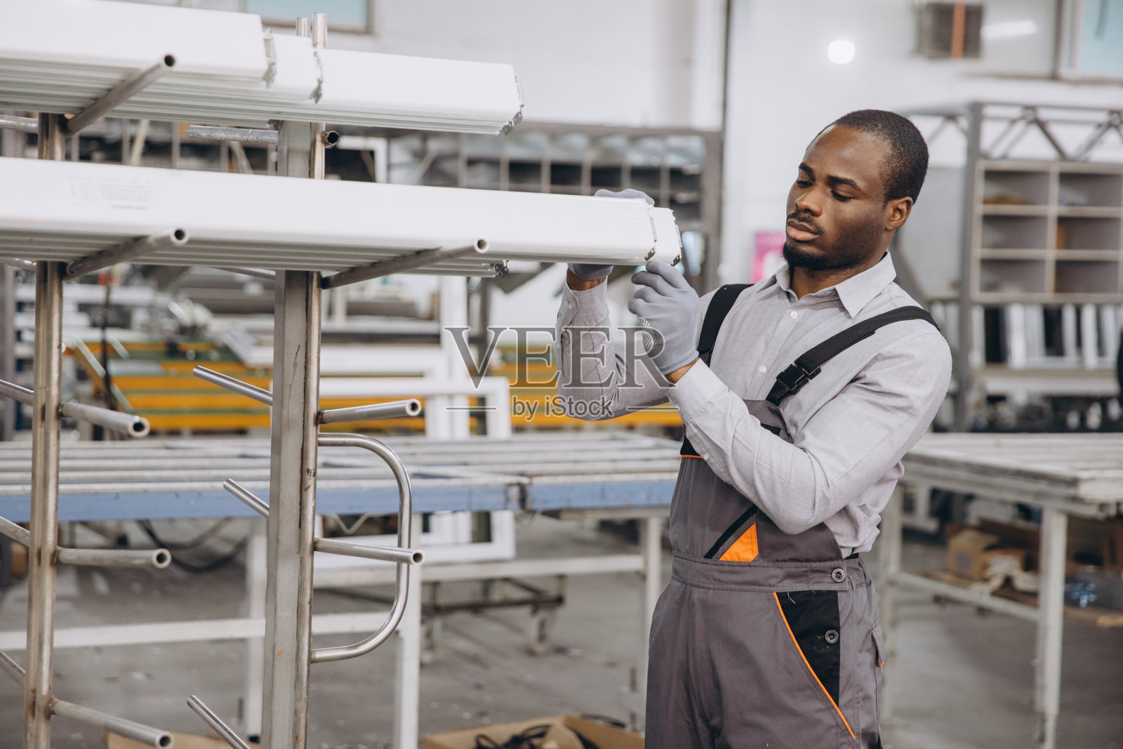 工厂工人在检查用于窗户和门生产的铝型材照片摄影图片