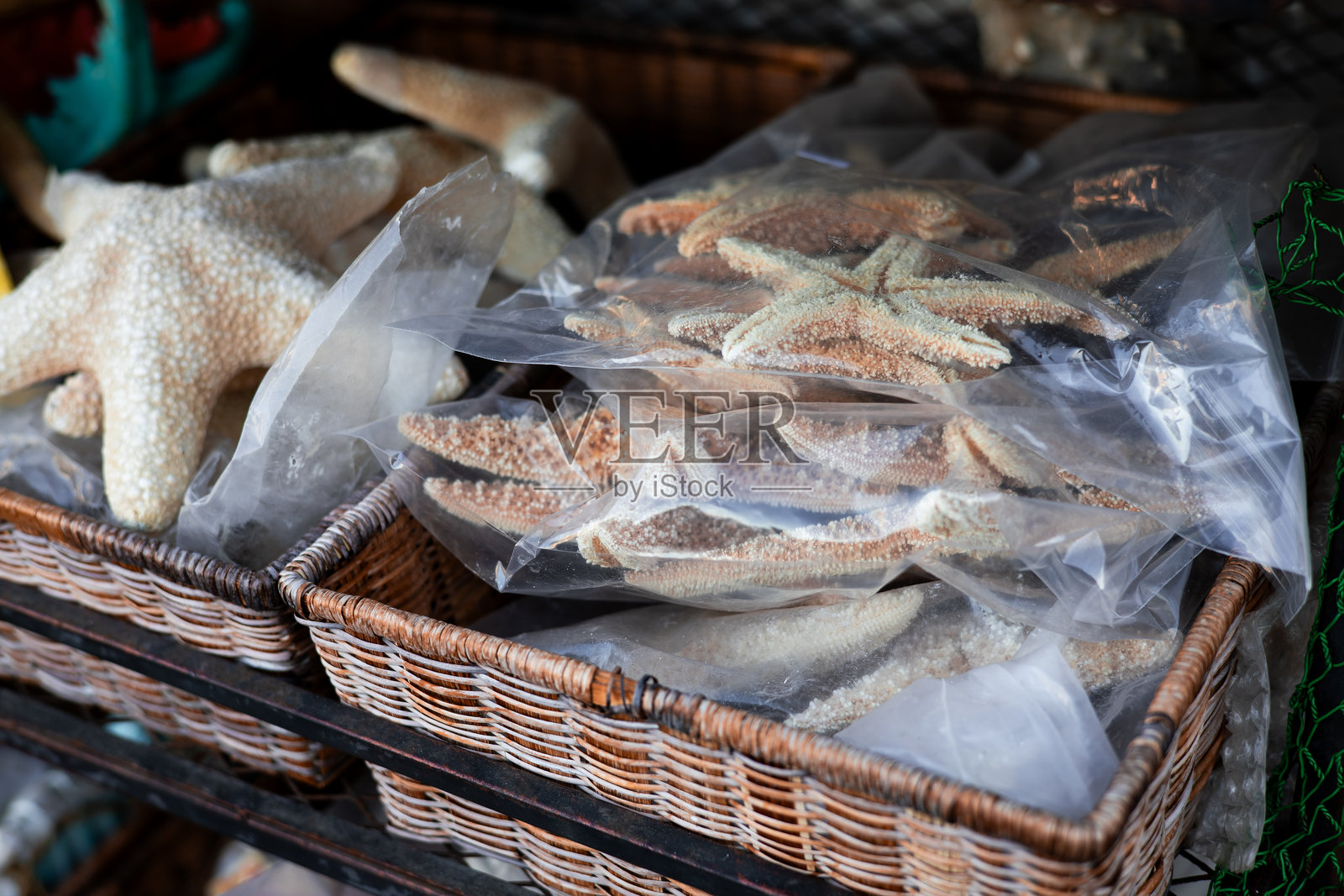 市场摊位上展示的干海星放在篮子里照片摄影图片