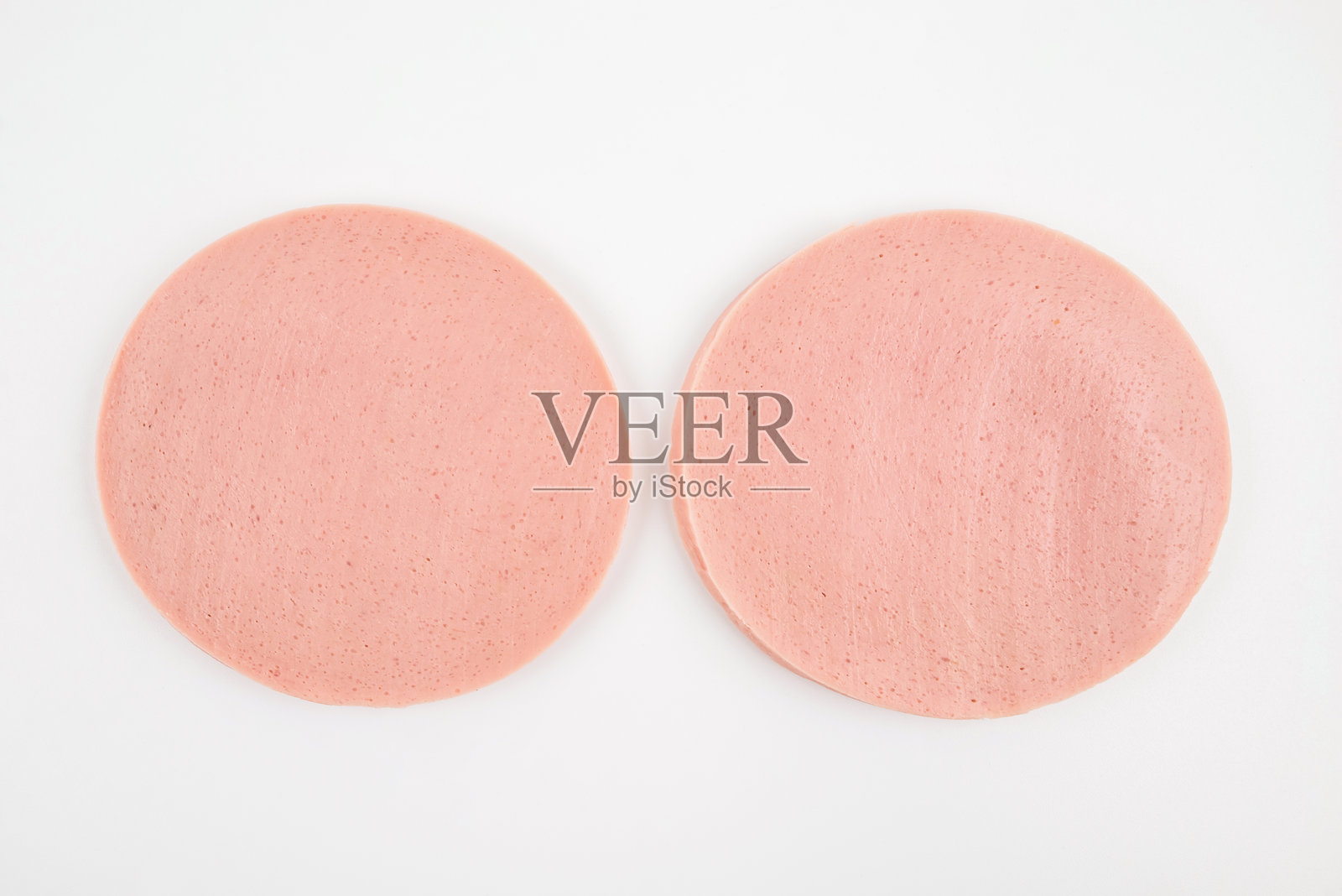 两片切好的熟香肠，孤立在白色背景上。俯视图。照片摄影图片