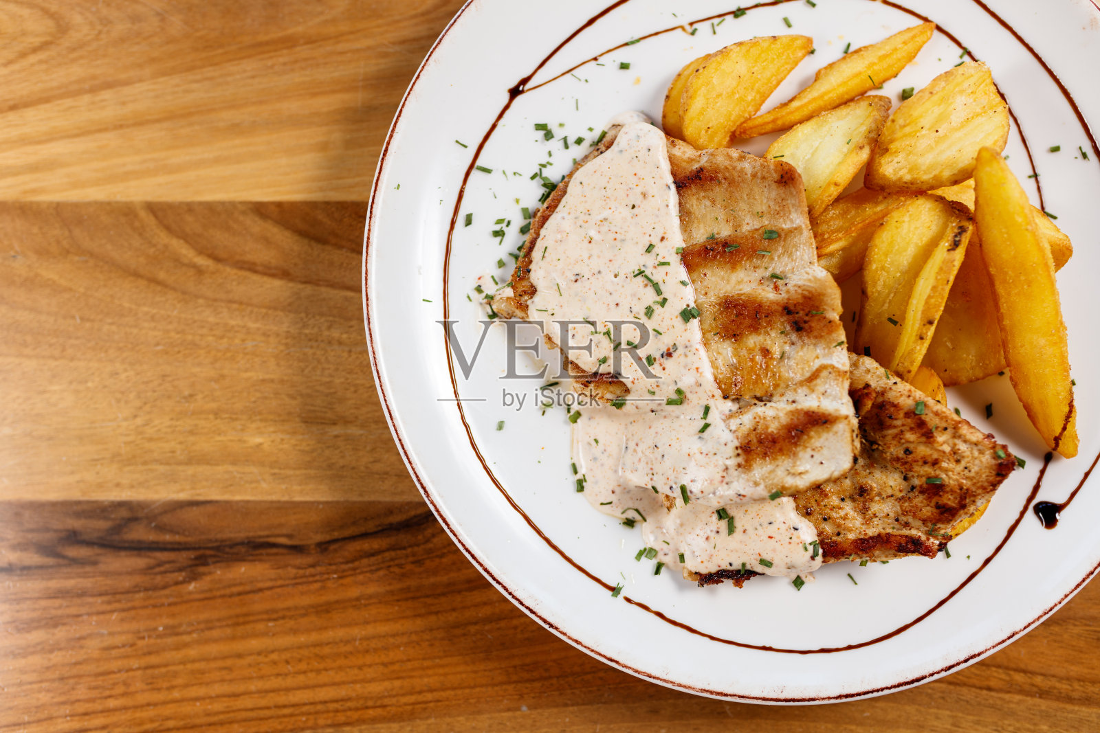 木质背景上的奶油酱烤肉和土豆照片摄影图片