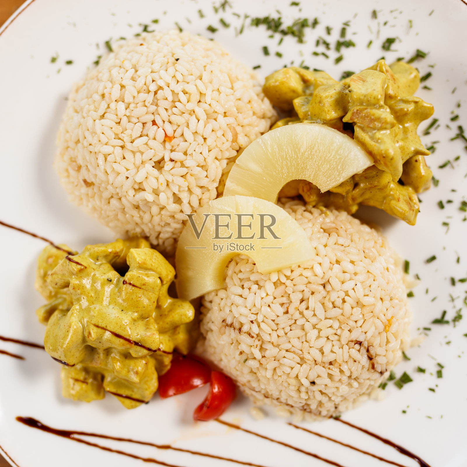 美味的鸡肉咖喱配米饭和菠萝装饰，摆放在木桌上照片摄影图片