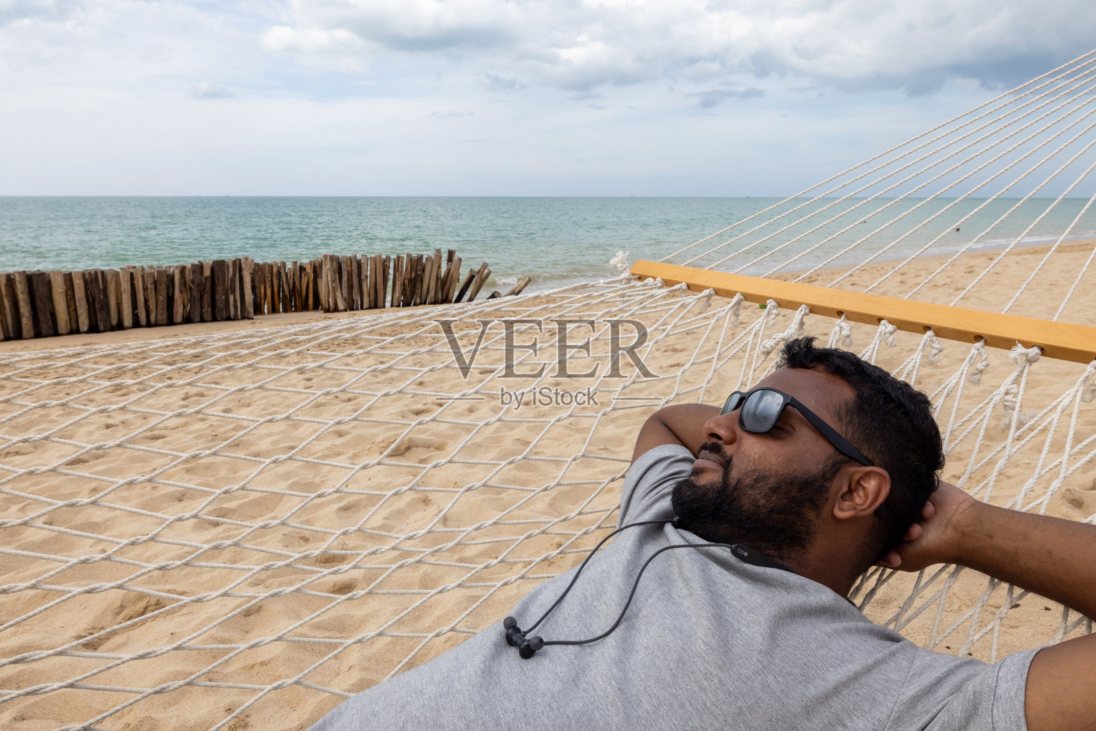 男人在沙滩上的吊床中放松照片摄影图片