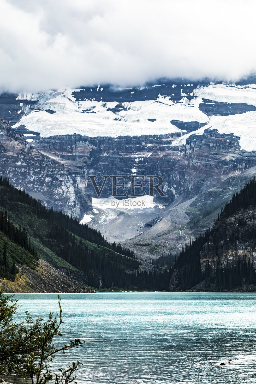 宁静的冰川湖米内万卡，四周环绕着高耸的阿尔卑斯山脉和郁郁葱葱的森林照片摄影图片