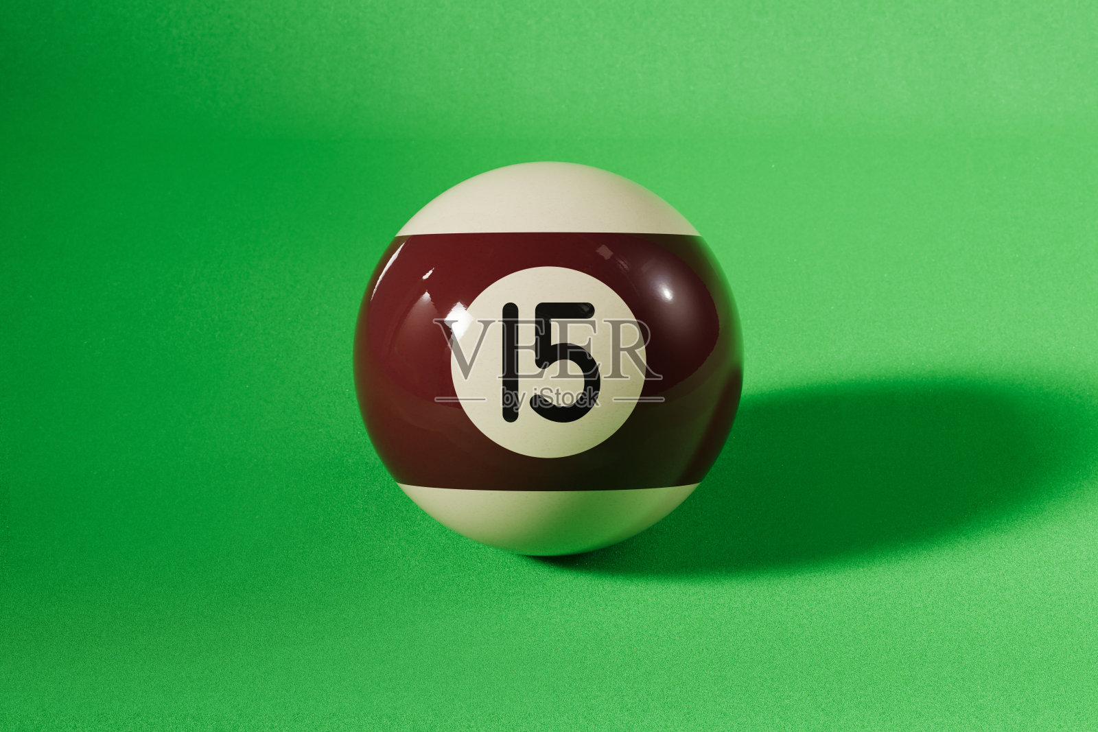 绿色背景上的棕色15号台球照片摄影图片