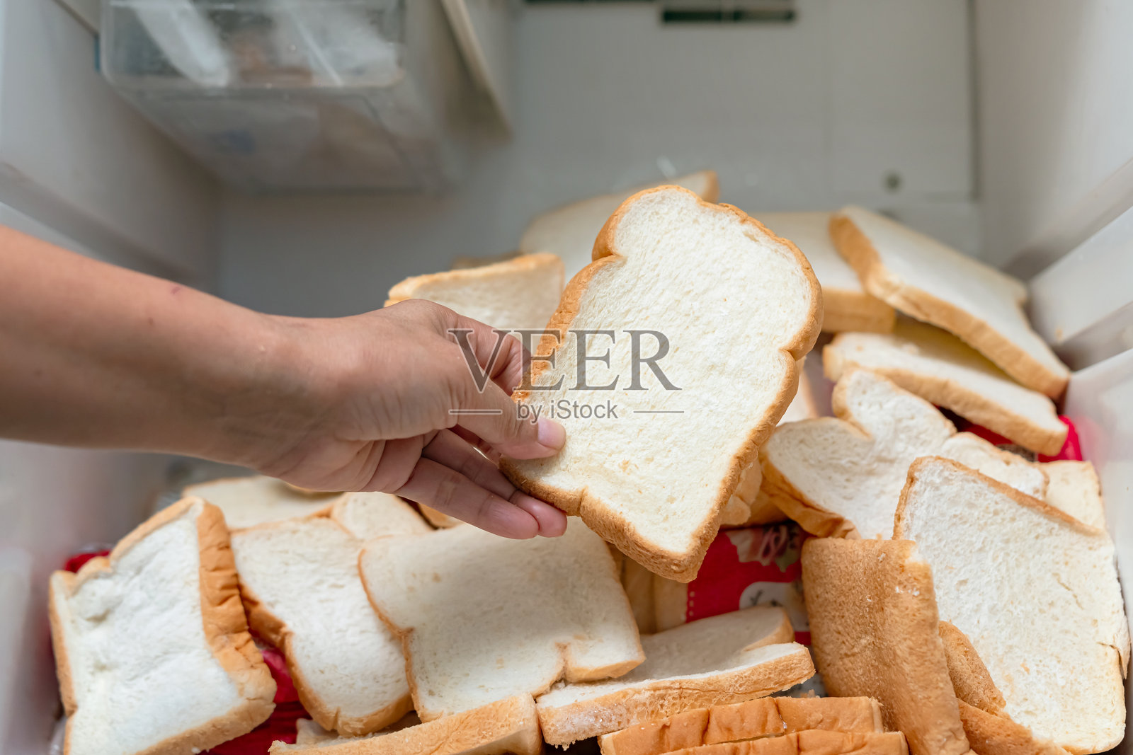 食物浪费。管家把冰箱里大量过期的面包扔掉了。照片摄影图片