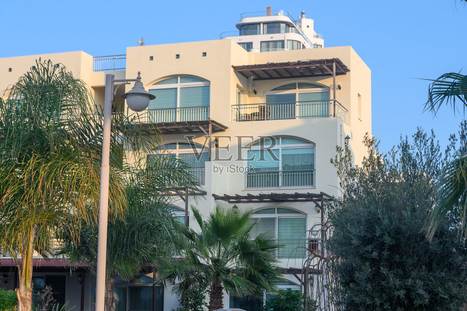 迷人的海岸建筑在阳光明媚的日子里被生机勃勃的绿植环绕照片摄影图片