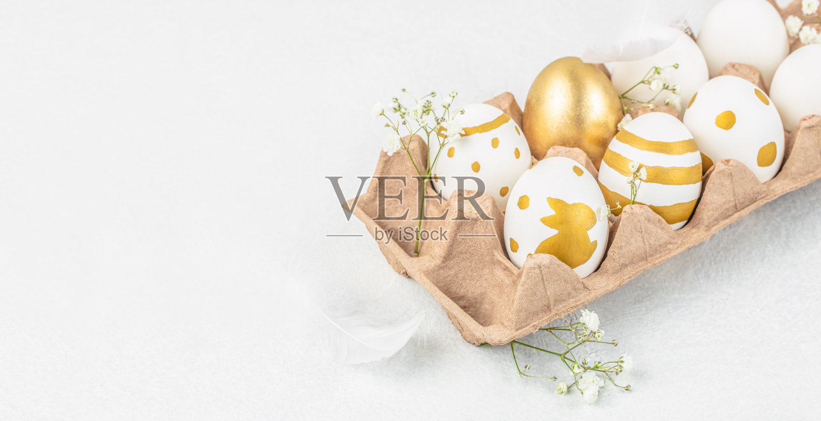 金色复活节彩蛋与春花在白色背景的纸托盘中，快乐复活节极简概念。留白空间。照片摄影图片