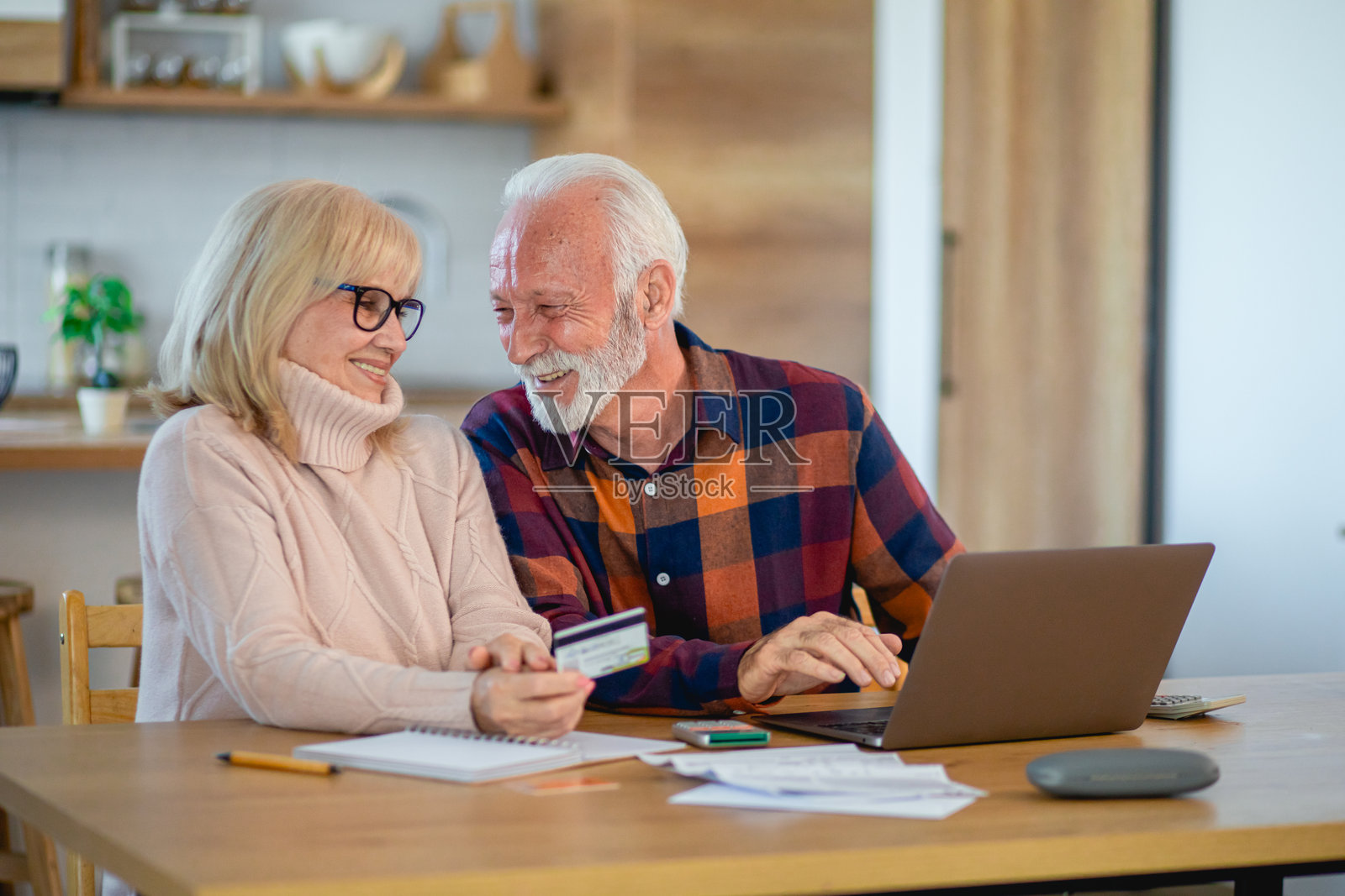 快乐的老年夫妇在使用笔记本电脑规划家庭预算照片摄影图片