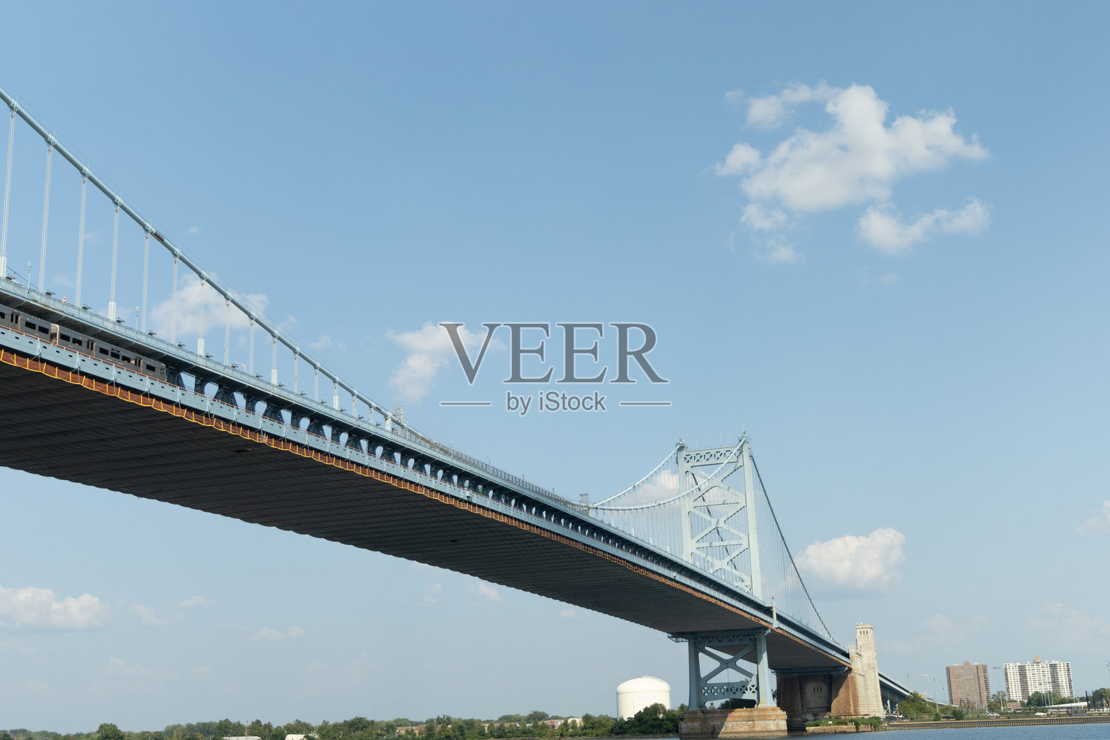 本杰明·富兰克林大桥横跨一片水域,头顶是湛蓝的天空。照片摄影图片