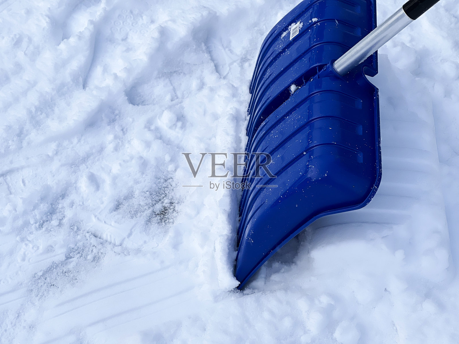 冬日阳光下，街道上覆盖着雪的蓝色铲雪器照片摄影图片