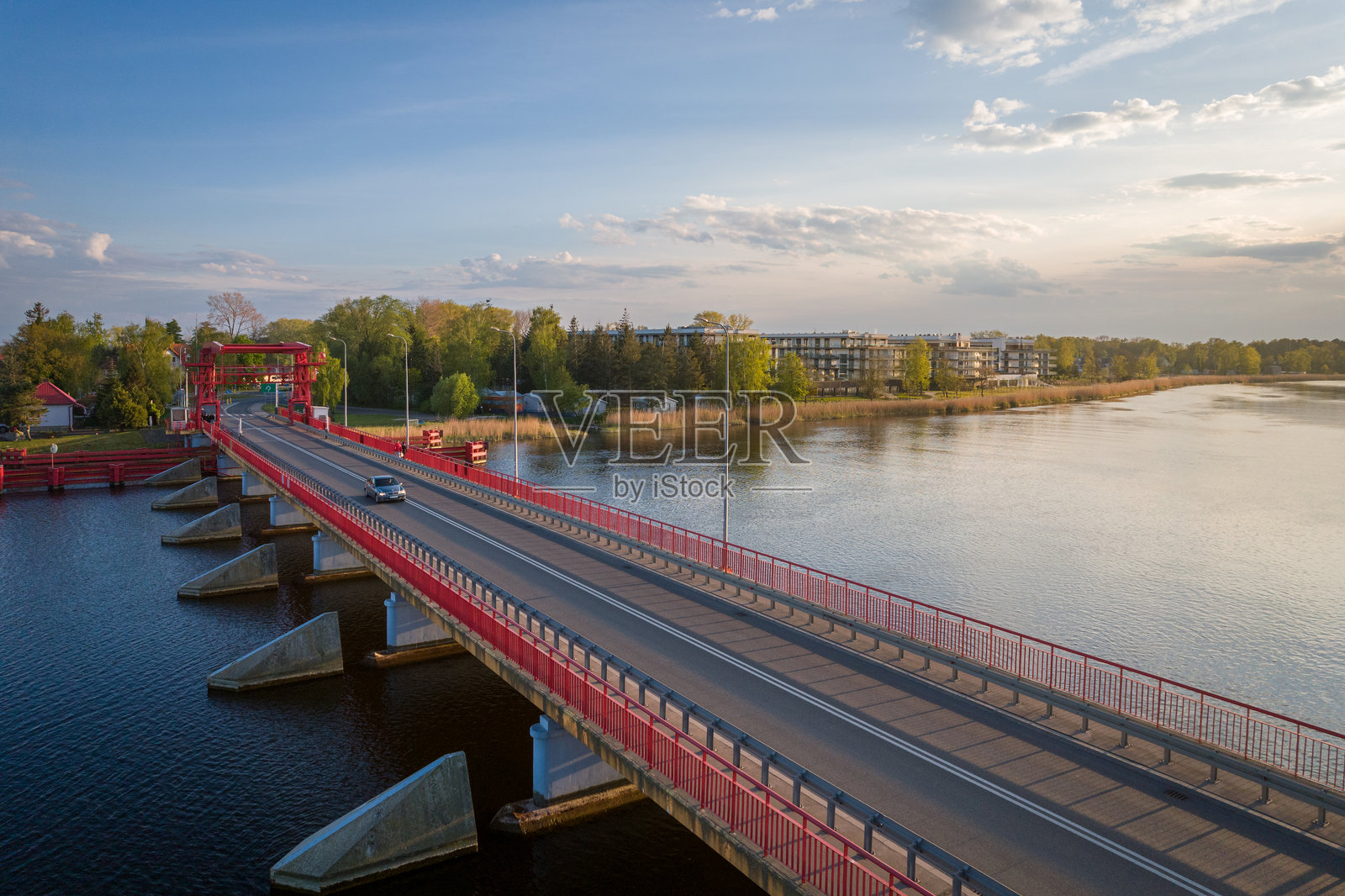 日落时分的红色可升降桥横跨水道。波兰迪兹诺夫照片摄影图片