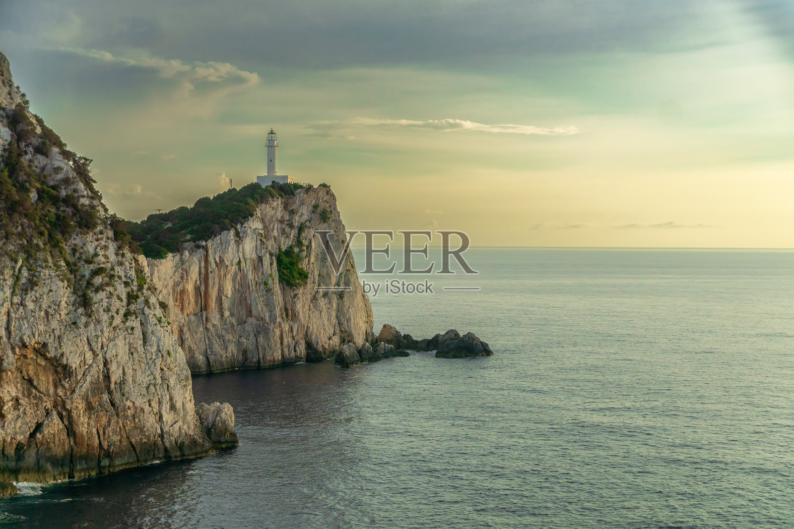 悬崖上的灯塔俯瞰着海洋照片摄影图片