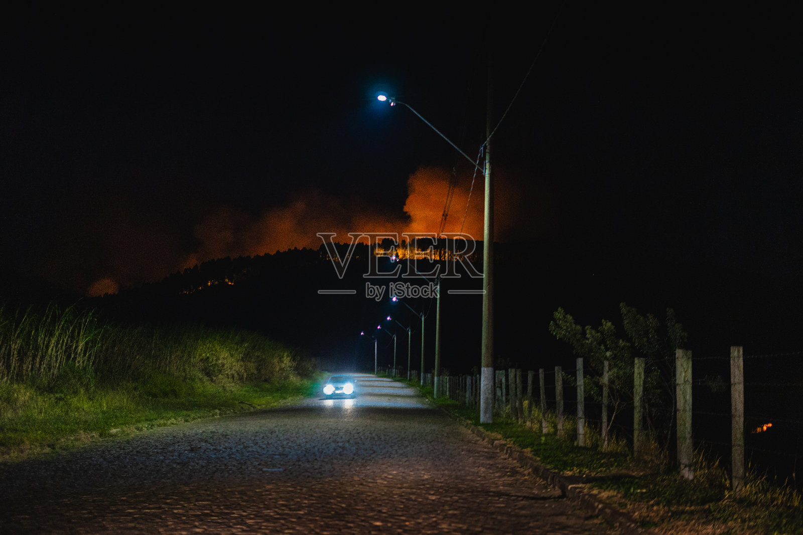 夜间从乡村道路观看森林火灾照片摄影图片