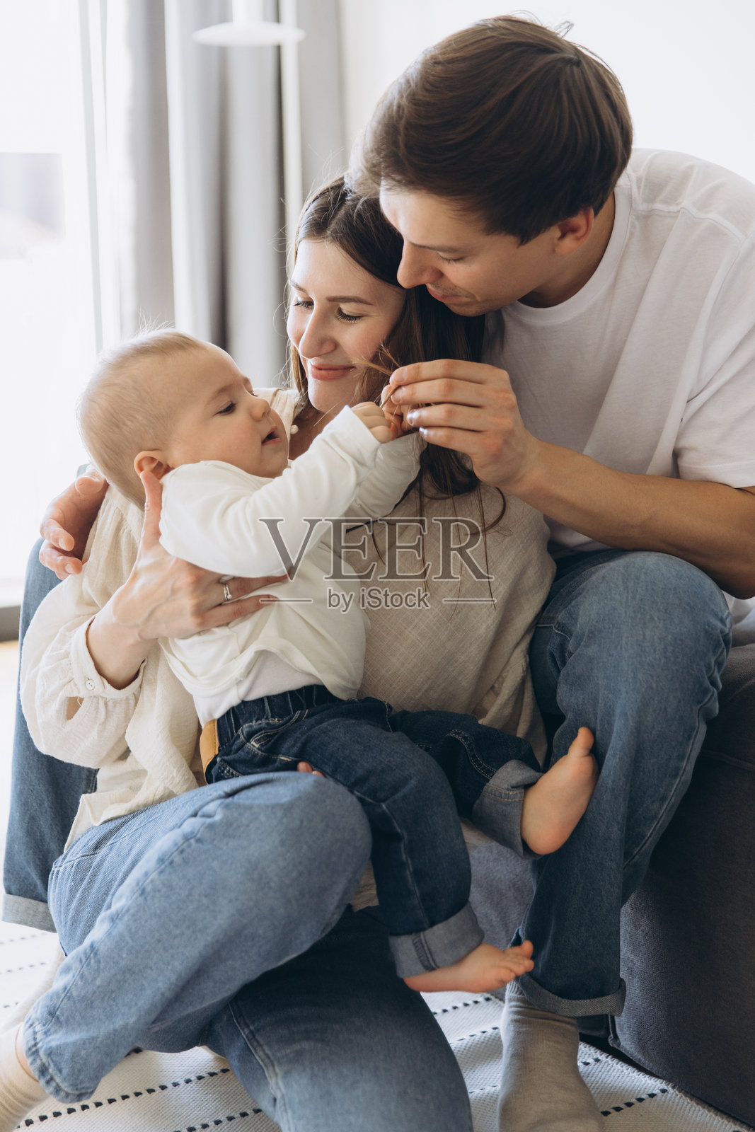 快乐的家庭在家中与他们的婴儿儿子玩耍照片摄影图片