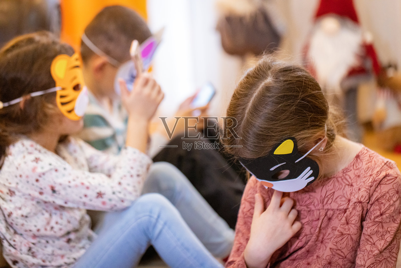 穿着服装的孩子们在玩手机游戏照片摄影图片