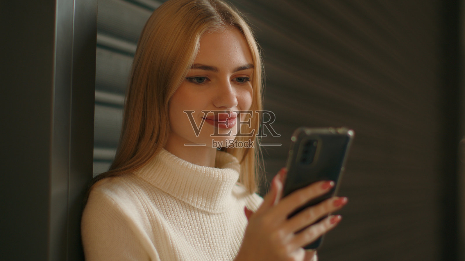 白人女孩在室内使用手机，正在智能手机触摸屏上打字，发送信息，女性商人、学生，快乐的客户，微笑着在线购物，浏览电子商务移动应用和社交媒体。照片摄影图片