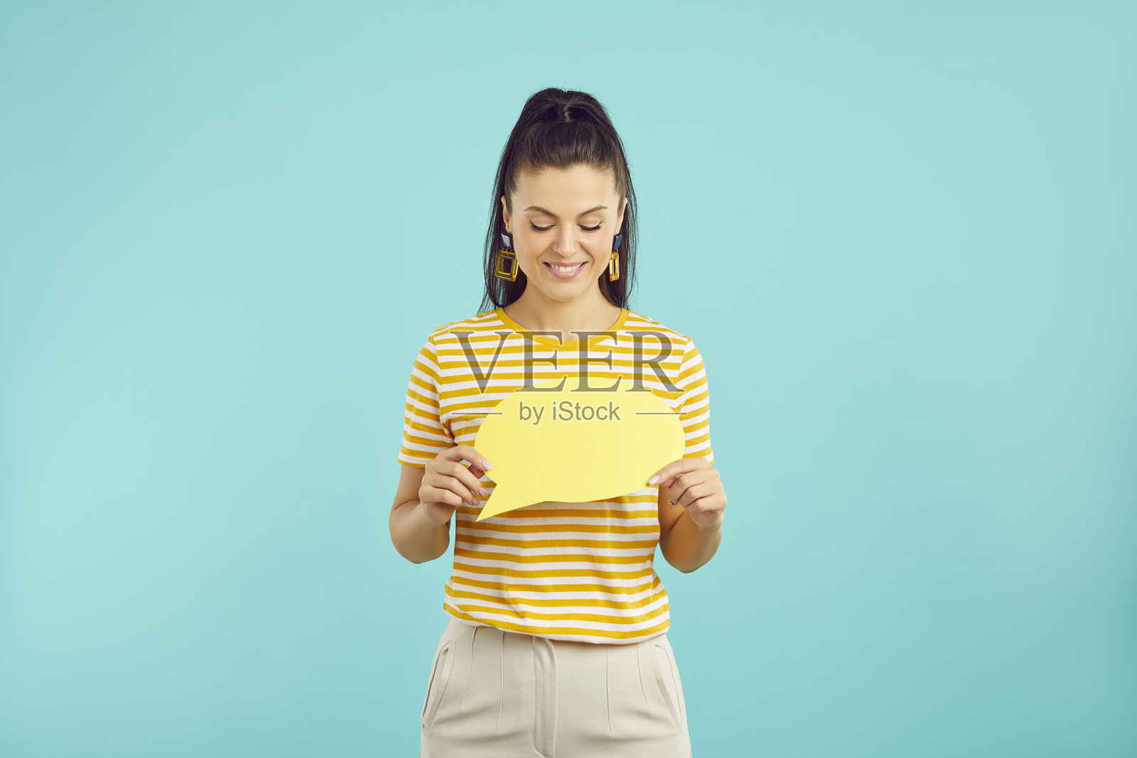微笑的女孩手持带有空白内容的对话气泡照片摄影图片