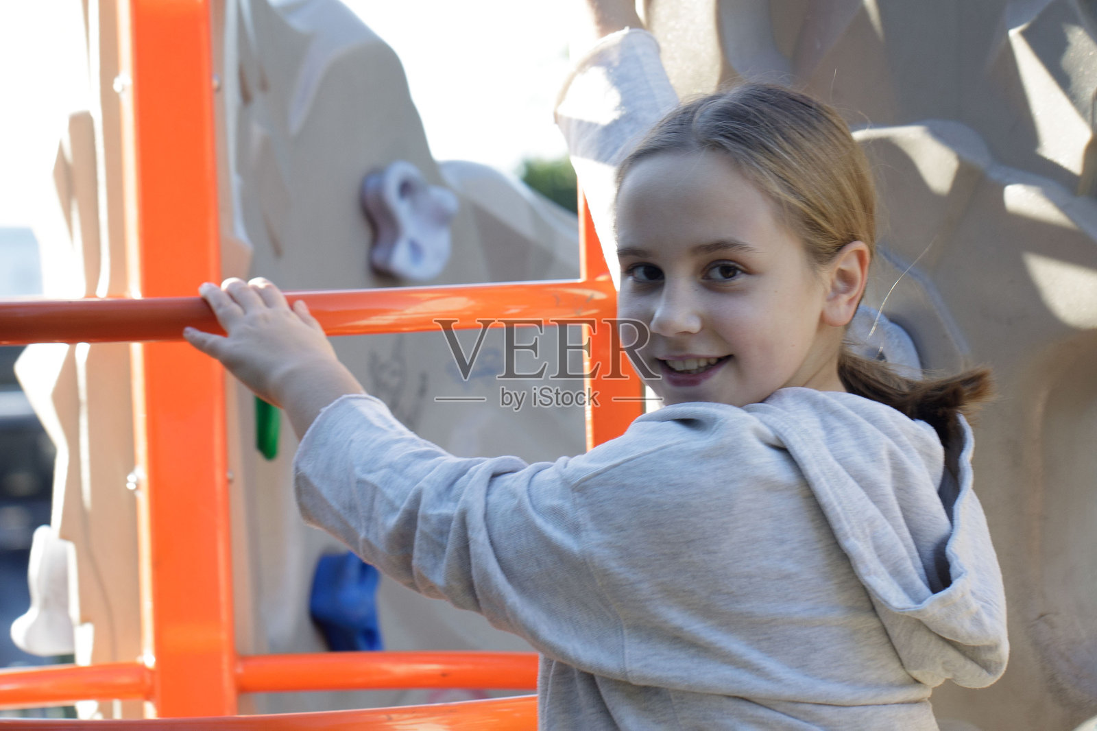 游乐场上小女孩的特写肖像。孩子们在户外玩耍。童年、快乐和休闲活动的概念。照片摄影图片