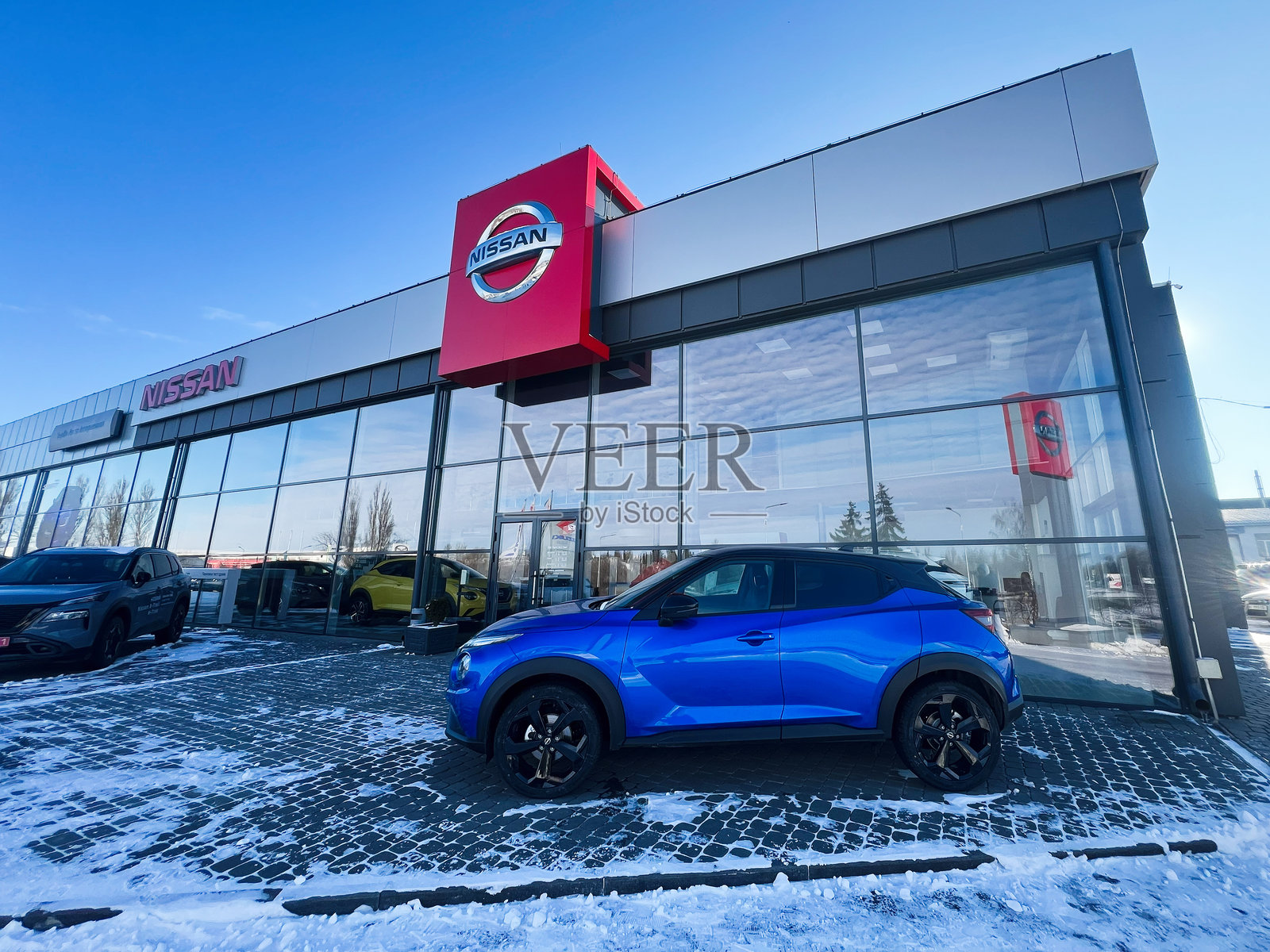 现代日产展厅,雪天停放着一辆蓝色汽车照片摄影图片