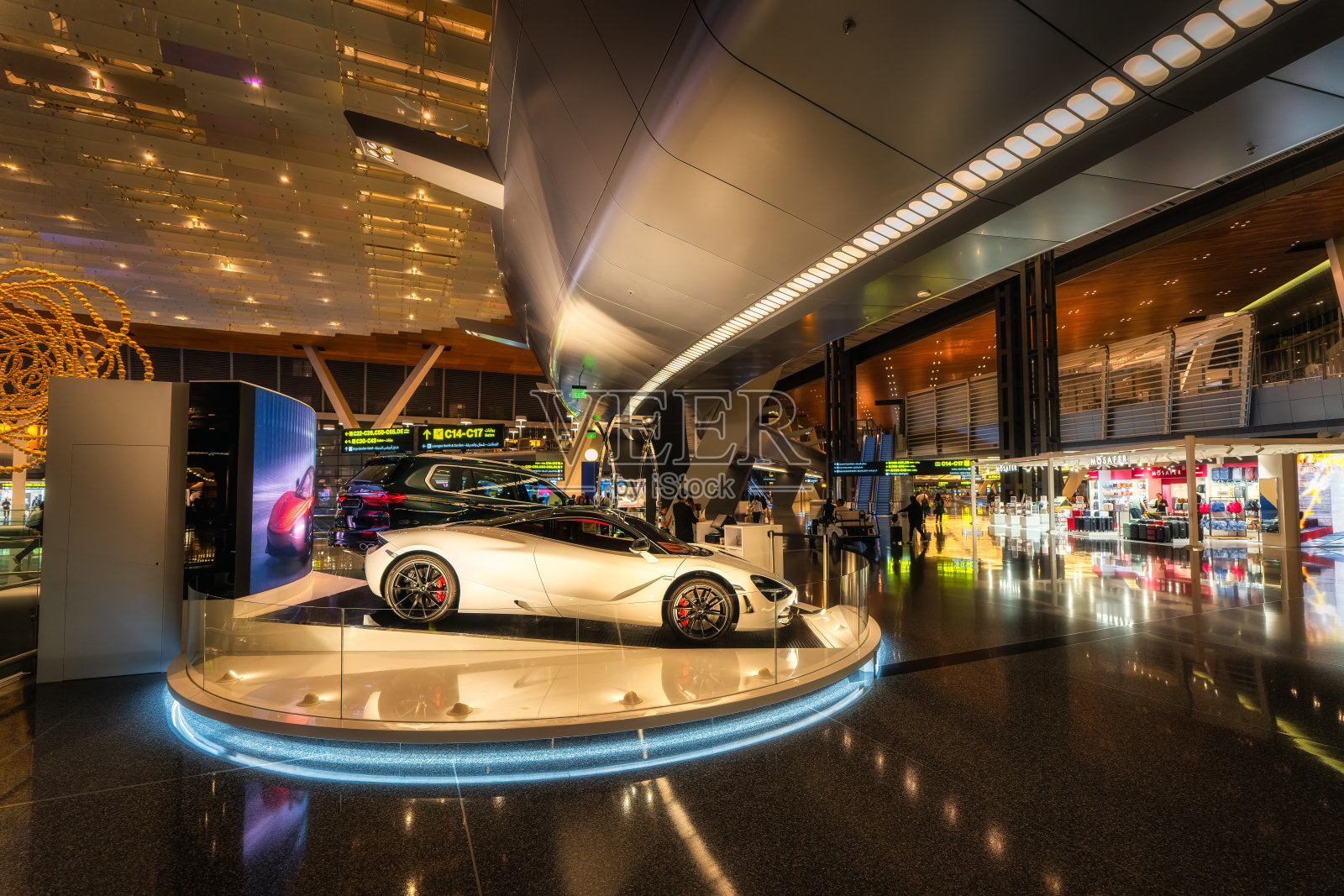 一辆优雅奢华的跑车在现代机场航站楼环境中吸引眼球。照片摄影图片