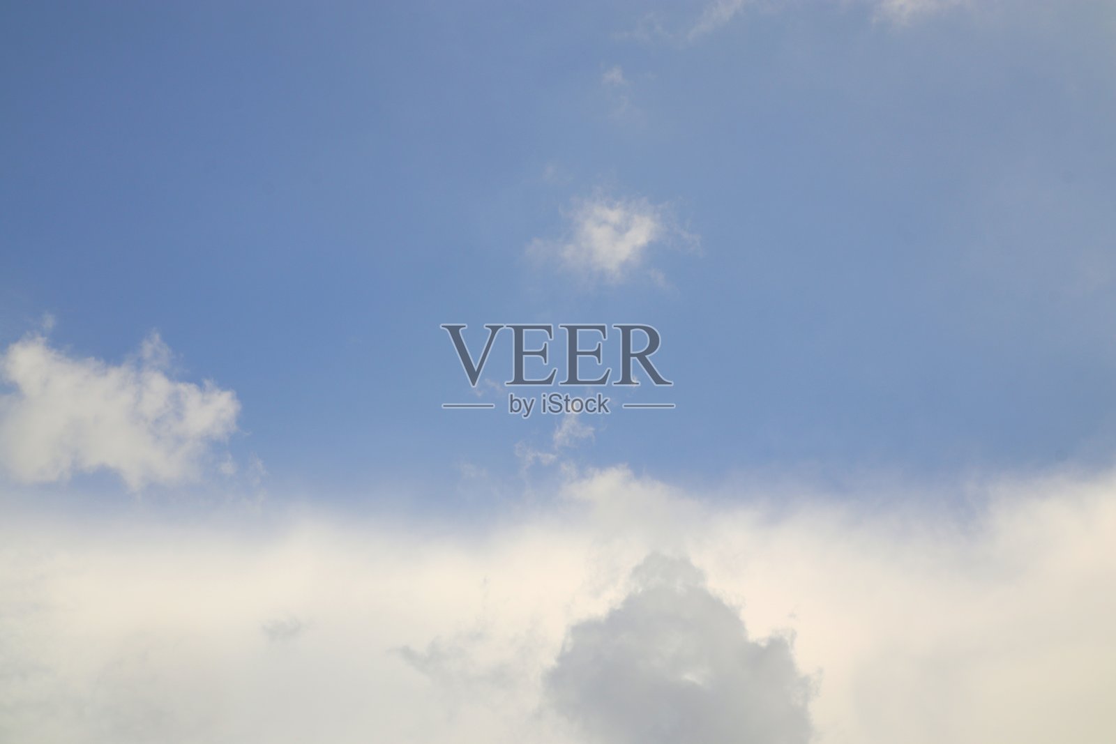 美丽的蓝天上漂浮着蓬松的云朵，形成了有趣的自然图案。照片摄影图片