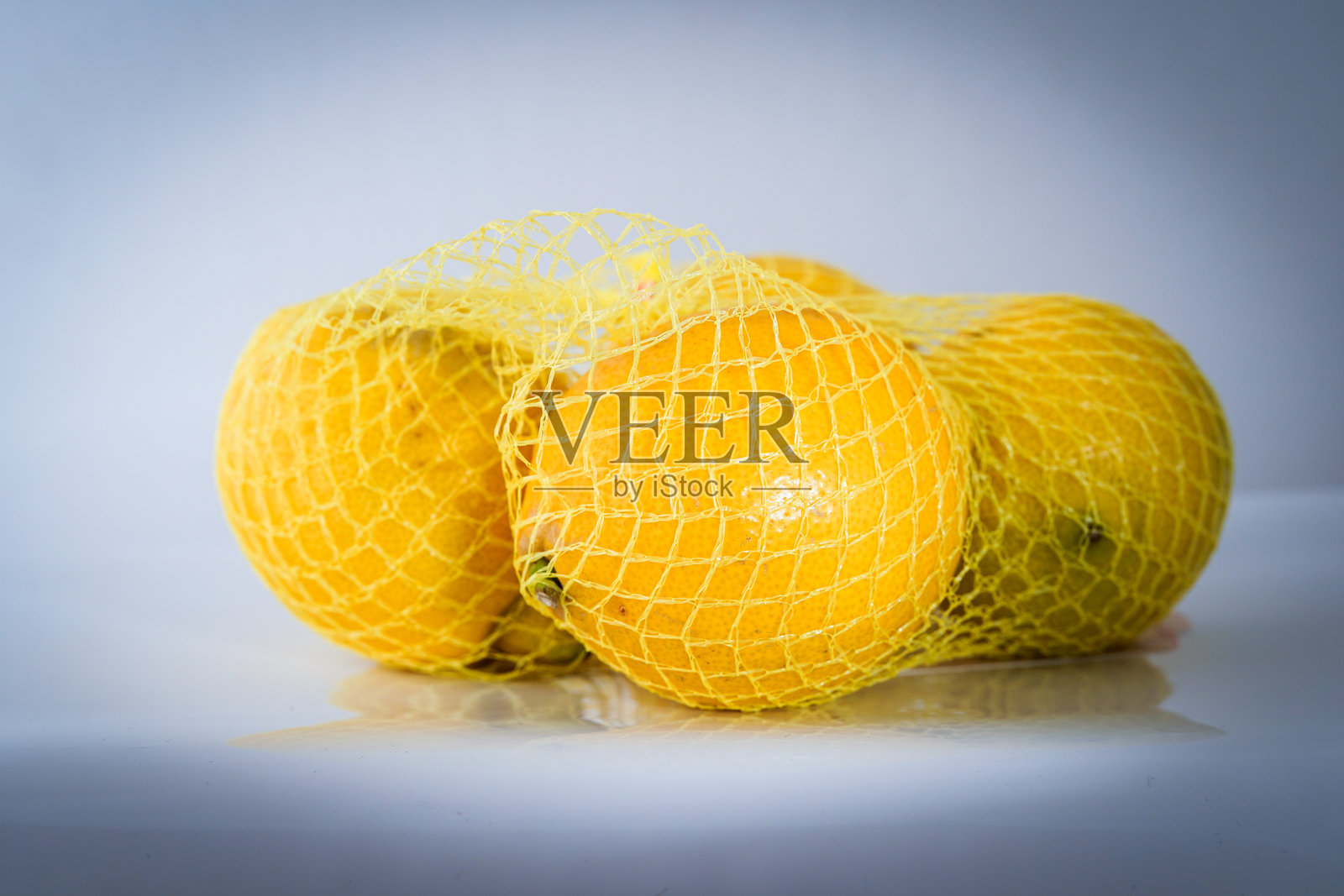 新鲜柠檬用网袋包装，准备出售照片摄影图片