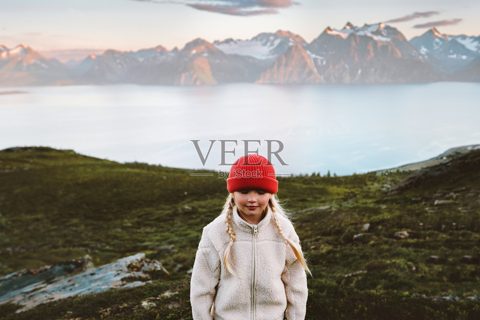 挪威家庭旅行生活方式的孩子徒步旅行，5岁女孩戴着红色帽子在探索北方斯堪的纳维亚自然的林根阿尔卑斯山。照片摄影图片