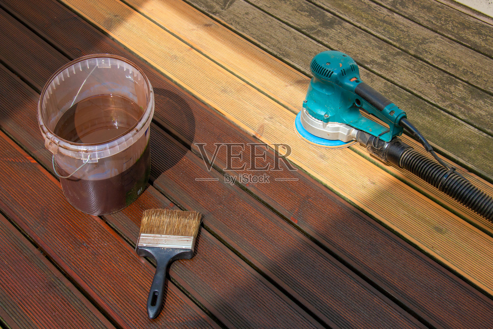 旧木材翻新，使用刷子涂抹木材染色剂，经过电动工具打磨后。照片摄影图片