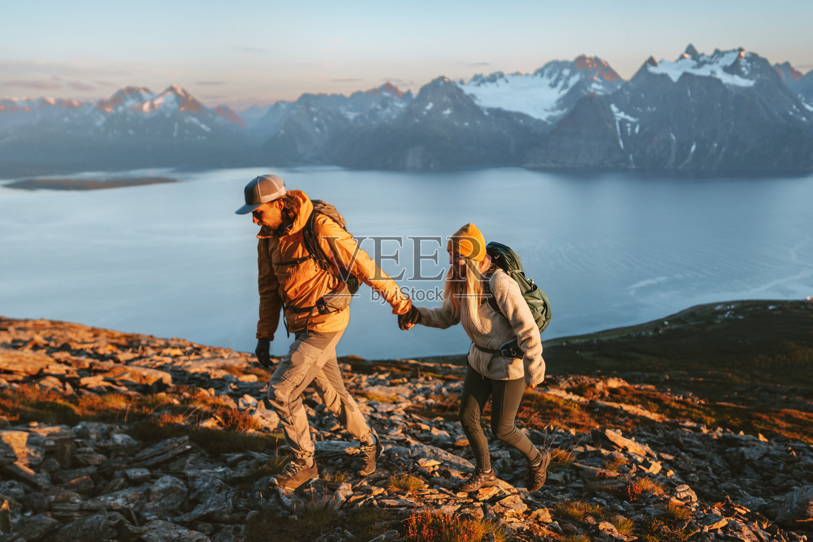 情侣在挪威的山脉中徒步旅行，朋友们手牵手一起攀登，享受积极的假期，健康的生活方式，家庭冒险之旅，男女共同探索林根阿尔卑斯山，冒险与耐力。照片摄影图片