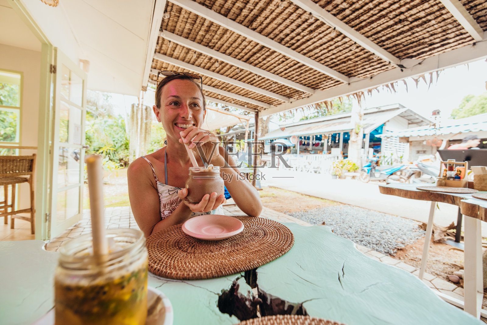 女性在户外咖啡馆享受冰饮料照片摄影图片