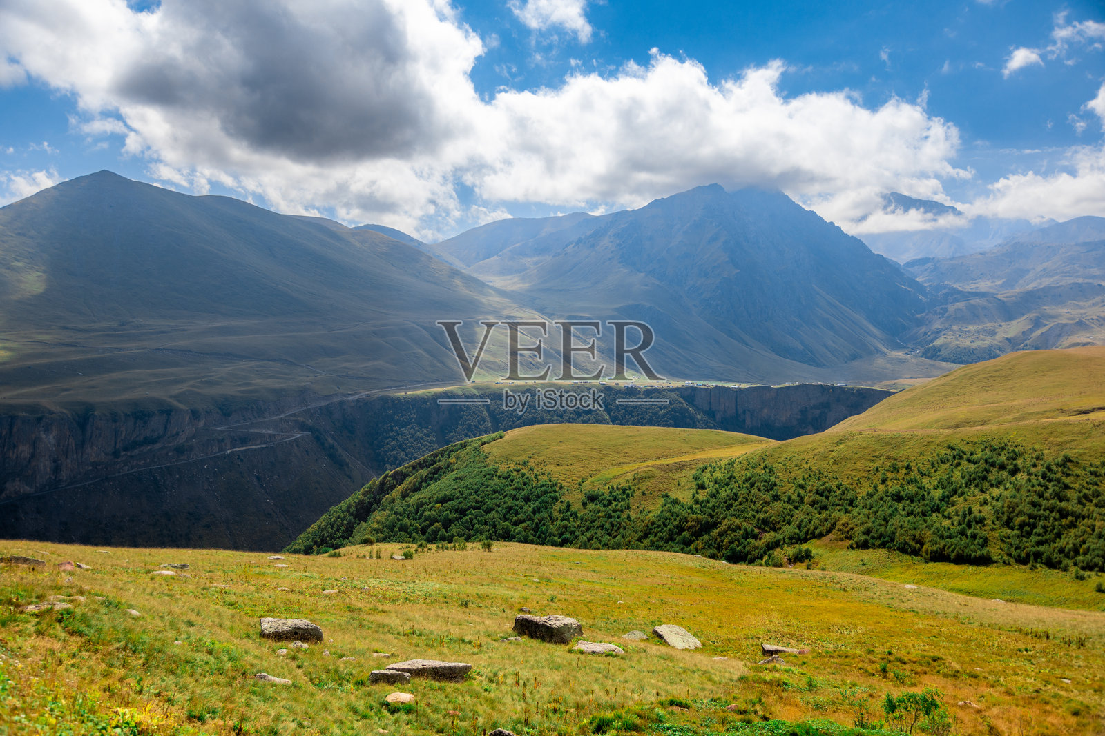 通往北高加索埃尔布鲁士山脚下的吉利苏地区的道路。山脉在晴朗的蓝天和几朵白云下。照片摄影图片