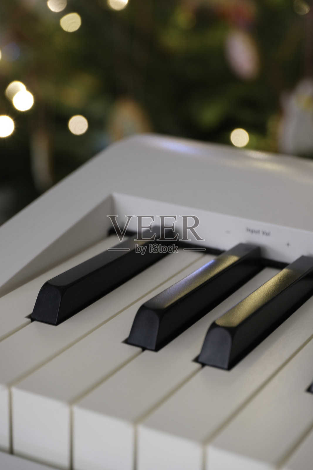 聚焦于钢琴键盘，背景散发柔和的节日光辉。照片摄影图片