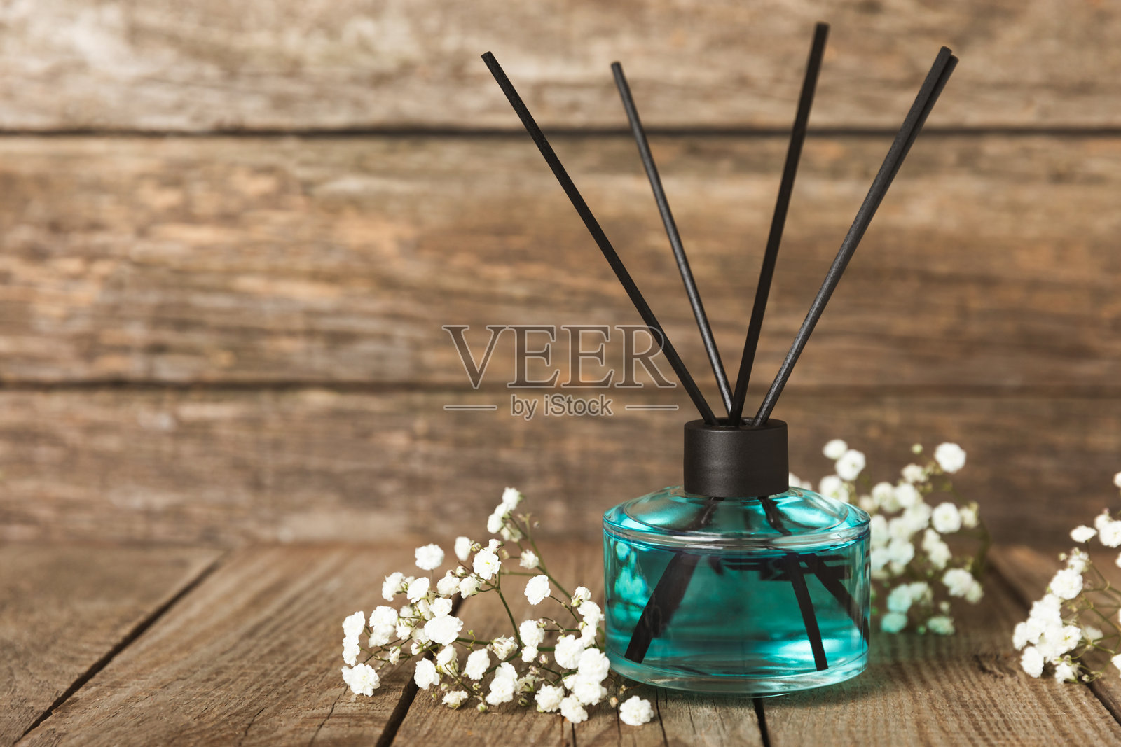 木桌上的芳香藤条空气清新剂。具有天然水果、花香和香料香气的扩散器。室内香氛。奢华的家用香水。橙子、青柠、咖啡、肉桂、八角、香草和兰花。照片摄影图片